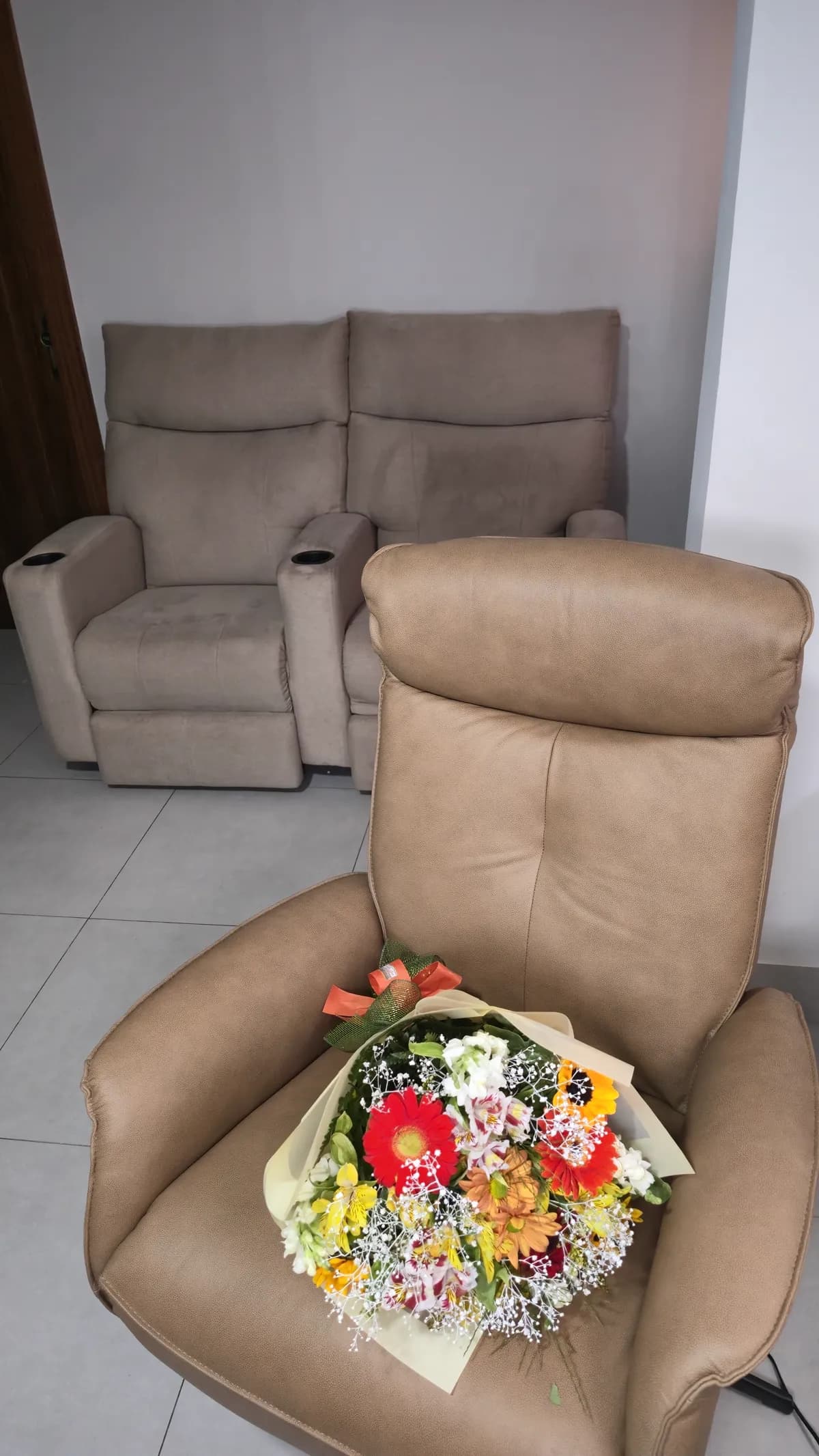 Poltrona reclinável bege da Damie na sala de estar da Cecília.