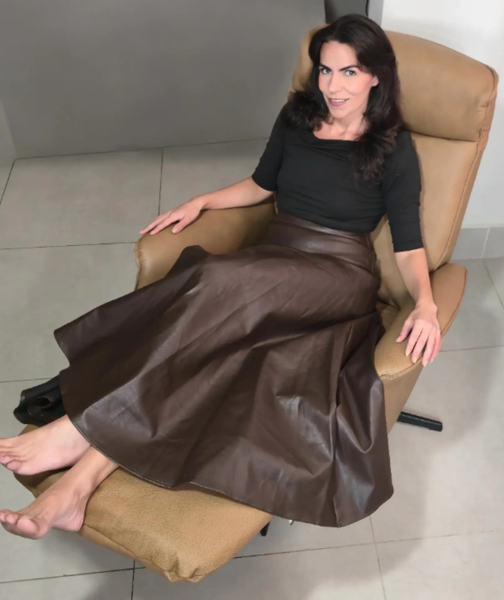 Cecília usando uma poltrona reclinável Damie com o apoio para as pernas aberto.