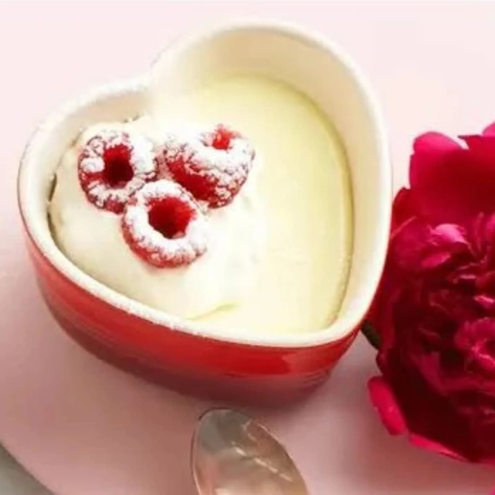 Ramekin vermelho em formato de coração da Le Creuset com creme e framboesas